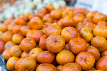 Tangerines in shop window. Stocks of fruits in stores storage. Fresh fruit vegetable harvest from producer is already on store shelves.