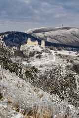 Winter landscape castle ruin snowy hills leafless trees sunny day in P&aacute;lava, Czech Republic