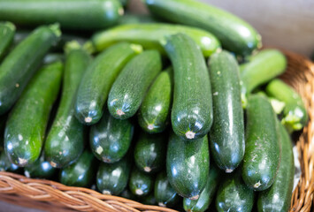 Ripe zucchini are grouped in pyramid on shop window. From producers farmer to consumers table..