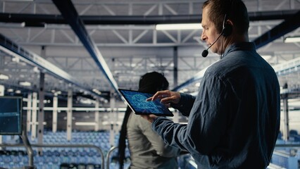 Data center engineer using AI on tablet to help clients resolve website hosting problems. Server...