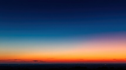 A sunset takes place in the evening sky. The colors shift from blue to orange and pink creating a colorful scene above a distant horizon. Nightfall approaches as the day ends.
