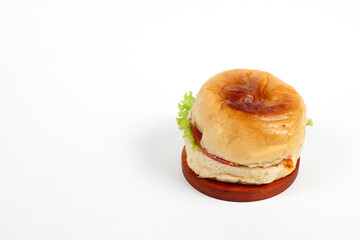 hamburger on round wooden board isolated on white background
