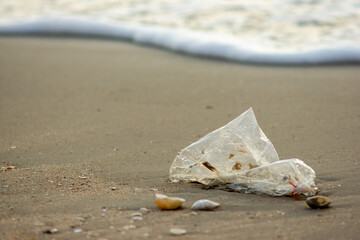 Plastic Waste Scattered on Beach Sand. Plastic waste on beaches is a serious global problem.
