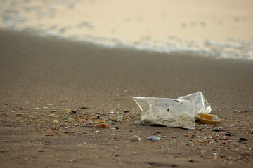Plastic Waste Scattered on Beach Sand. Plastic waste on beaches is a serious global problem.