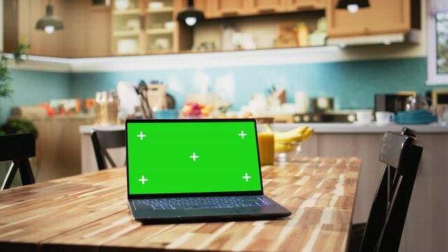 Chroma key display in kitchen interior with minimalist style furniture and lighting. Table and counter decorated with fruits, vegetables and cooking tools, highlighting a warm elegant home.
