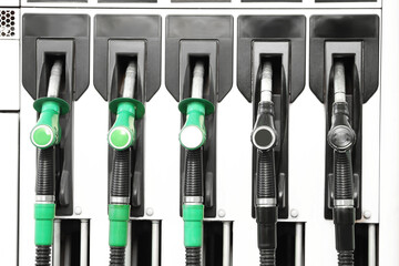 Row of fuel pump nozzles at gas station, green and black petrol and diesel dispensers close up, transportation energy, refueling service, fossil fuel industry concept © Pixel-Shot