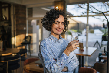 Woman drinking water enjoying a healthy break in cafe