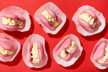 Sweet heart-shaped macaroons on red background. Valentine's Day celebration