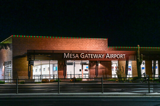 Mesa Gateway Airport terminal exterior illuminated at night with prominent signage and glass entry, illustrating regional aviation infrastructure and commercial passenger transportation services