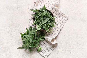 Bowl with fresh arugula leaves on white background