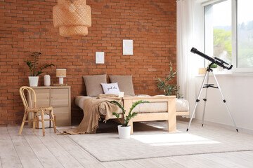 Interior of bedroom with cozy bed and modern telescope near window