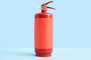 Obraz premium Fire extinguisher on blue background