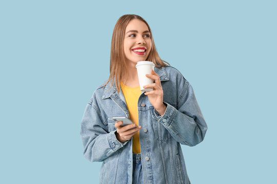 Young woman with mobile phone and cup of coffee on blue background - Powered by Adobe