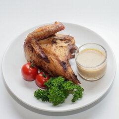 Roasted chicken breast quarter served with creamy sauce, cherry tomatoes, and parsley on a white plate. Rustic food photography ideal for restaurant menus, food blogs, and editorial cuisine content.