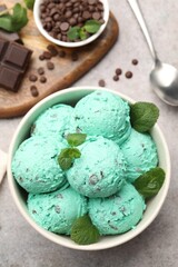 Yummy mint chocolate chip ice cream served on grey, flat lay