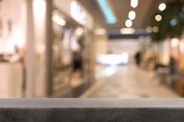Empty grey table against blurred view of shopping mall. Space for design