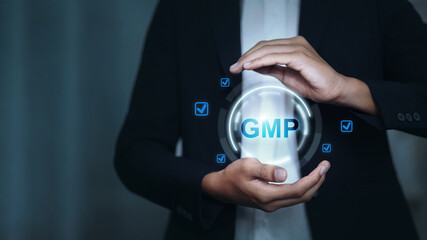Businessman hands protecting GMP certification standard logo for quality control concept.