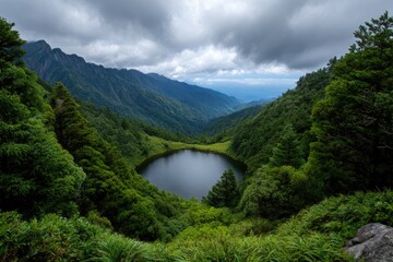 A secluded lake surrounded by lush verdant mountain slopes under a cloudy sky