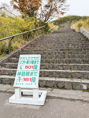 長い石段と案内板が続く山道の風景