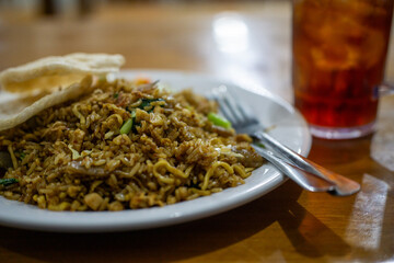 Plate of Nasi Goreng with Cutlery and Iced Tea in Background