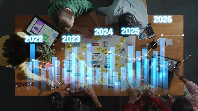 A vibrant overhead view of a business strategy meeting showcasing professionals analyzing growth charts and discussing future plans using various devices. Raster - Powered by Adobe