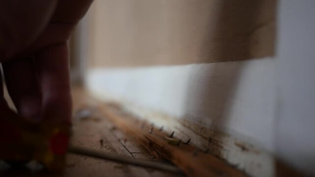 Carpet Removal Series - Man pries up tack strips