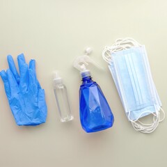 The picture shows gloves, a spray bottle, and a medical mask