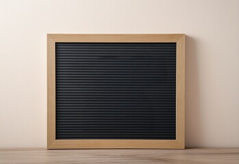 Black felt letter board with wood frame on table against wall for messages and announcements displaying quotes or marketing content signage