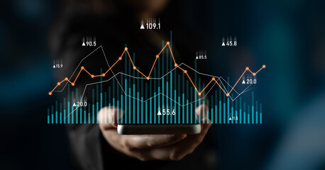 A business person holds a smartphone displaying dynamic financial graphs and statistics, representing data visualization and insights in corporate environments. Scalp
