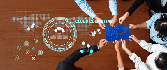 Diverse team collaborates around a wooden table, using puzzle pieces to symbolize cloud computing concepts, enhanced by digital graphics and technology elements. Trope