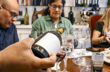 Hand pouring red wine during a tasting event