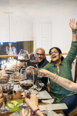 Hispanic friends toasting with red wine celebrating special occasion