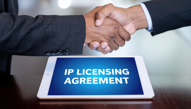 Business handshake intellectual property licensing agreement digital tablet legal rights professional setting contract negotiation partnership and trust are depicted this image emphasizing