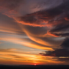 Fototapeta premium Vibrant sunset with dramatic clouds and orange glow