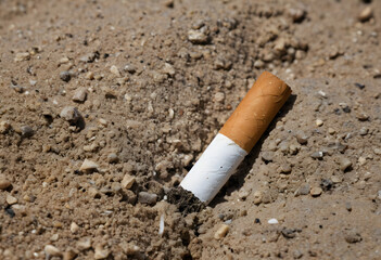 Cigarette butt polluting sand on beach causing environmental damage