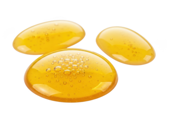 Close-up of three shiny yellow gel capsules with bubbles on a transparent background, isolated pharmaceutical or supplement pills.