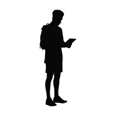 Silhouette of a Young Man or Student Standing with a Backpack, Using or Reading a Digital Tablet or E-Reader Device
