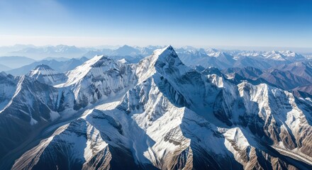 Spectacular aerial panorama of snow-covered mountain peaks against a clear blue sky offering a