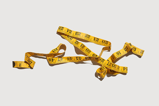 Yellow measuring tape in inches on a white background