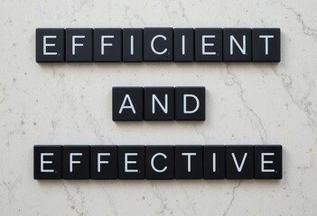 Fototapeta premium Black Letter Tiles Displaying Efficient and Effective on Marble Background