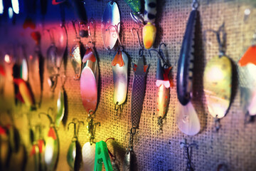 objects for fishing on a wooden pier close-up - hooks, baits, coil and hat