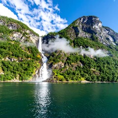 A stunning vista presents a cascading waterfall framed by lush green mountains and the calm, reflective waters below