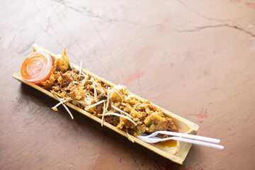 Pad Thai with fried mussels served in a bamboo tube.