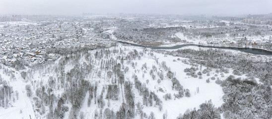 panoramic aerial view on suburb area of big city. snow-covered landscape at winter foggy day.