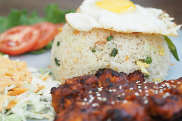 Fried rice with egg and grilled chicken on a plate