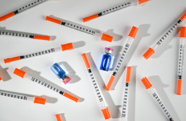 Glass Vial with Liquid Surrounded by Single Use Syringes