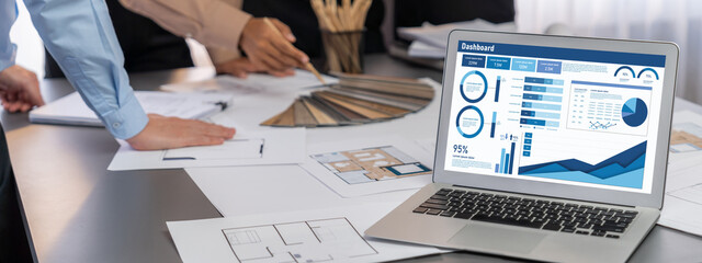 Group of interior architect designer discussing together on blueprint and laptop screen display...