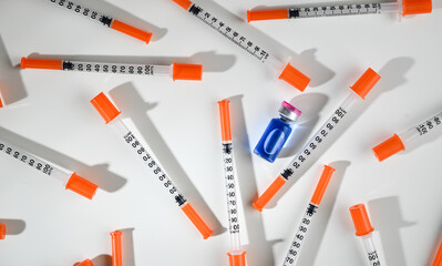 Glass Vial with Liquid Surrounded by Single Use Syringes