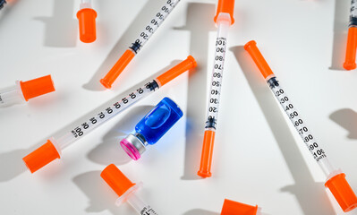 Glass Vial with Liquid Surrounded by Single Use Syringes