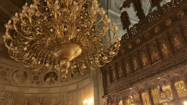 ornate romanian church interior with golden chandelier and detailed iconostasis